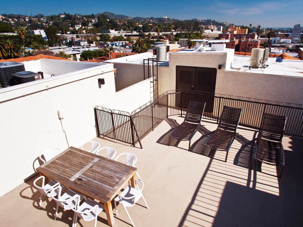 a table and chairs on a roof with a city in the background