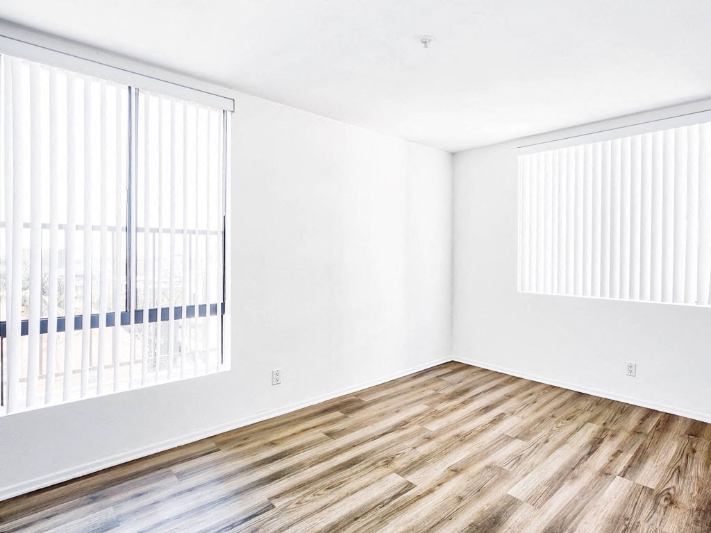 an empty room with white walls and wood floors