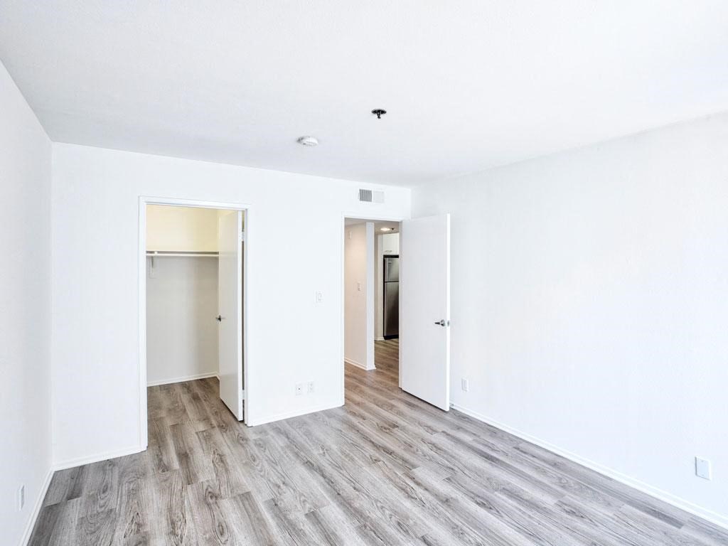 an empty room with white walls and wood floors