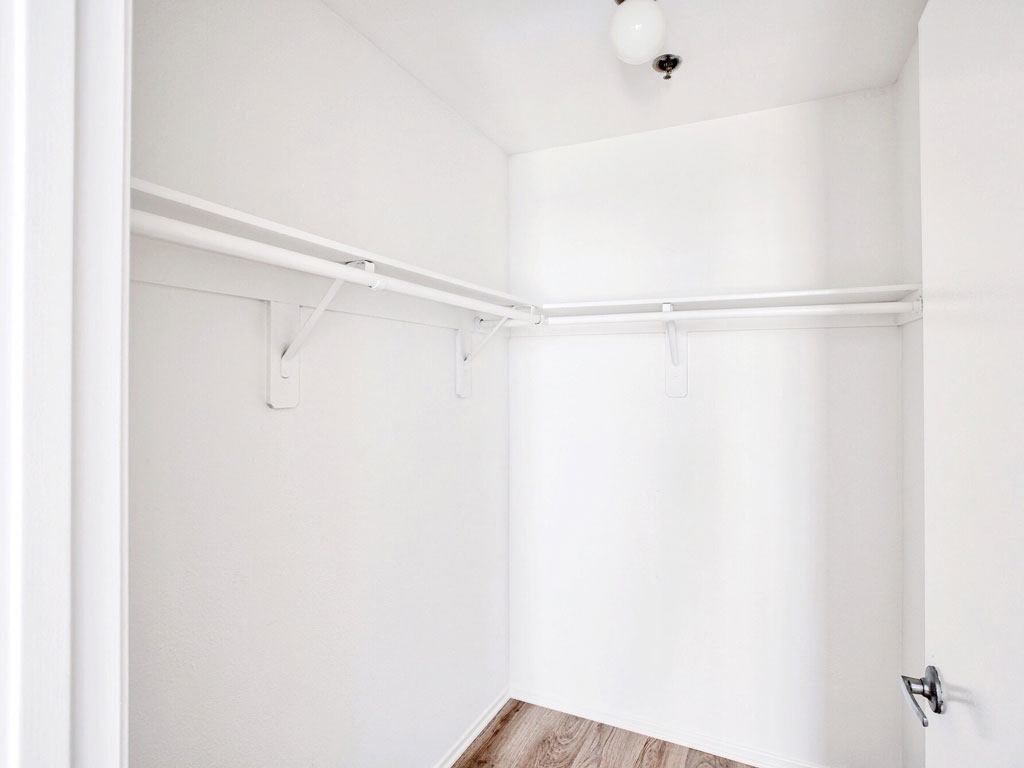 an empty room with white walls and a white closet