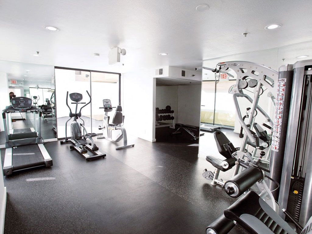 a gym with cardio machines and weights on the floor
