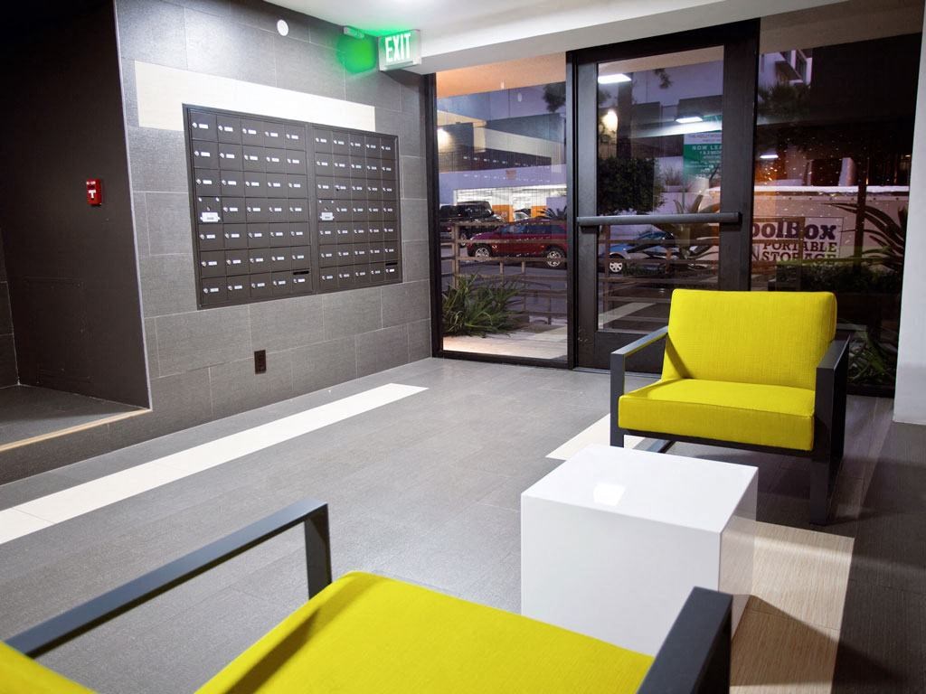 the lobby of a building with yellow chairs