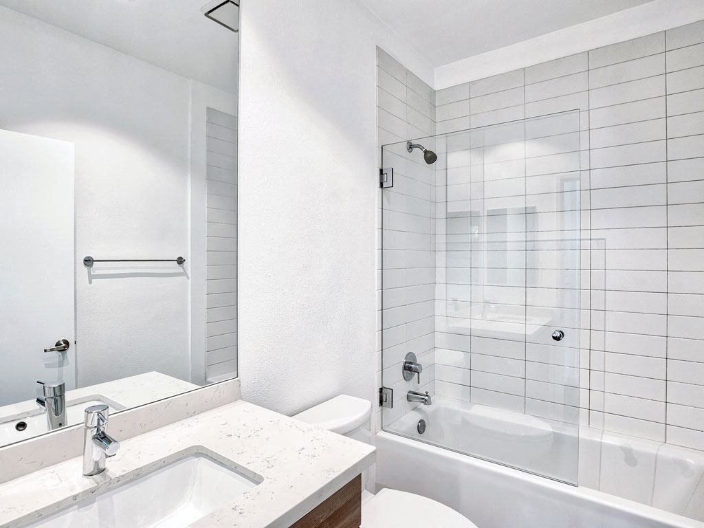 a white bathroom with a shower and a sink