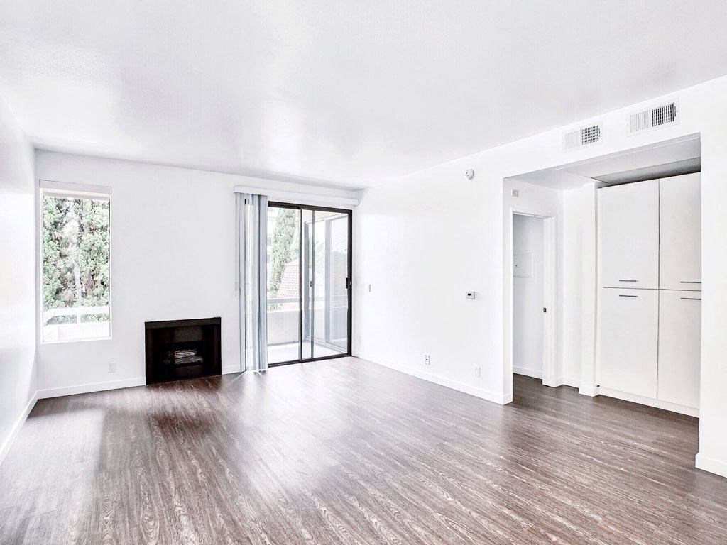 an empty living room with white walls and a fireplace