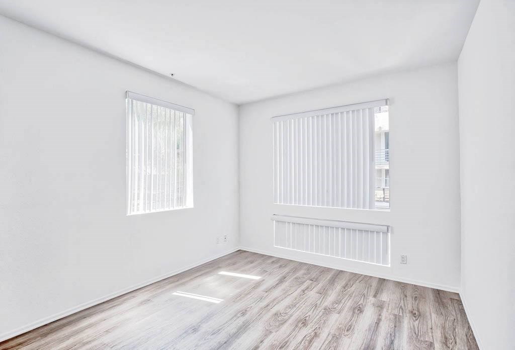 an empty living room with white walls and wood floors