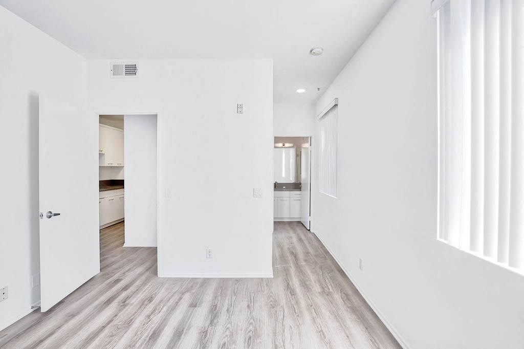 an empty living room with white walls and wood floors