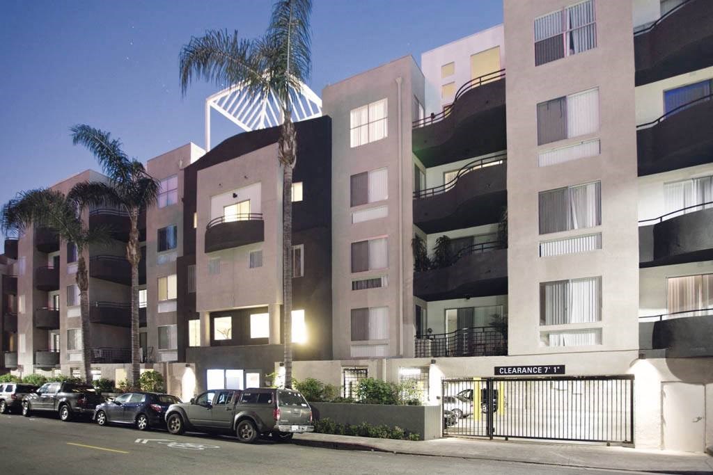 an apartment building with cars parked in front of it