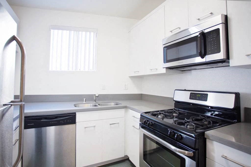 a kitchen with a stove microwave and sink