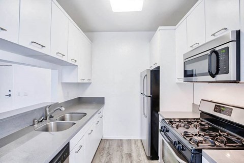 a kitchen with stainless steel appliances and white cabinets