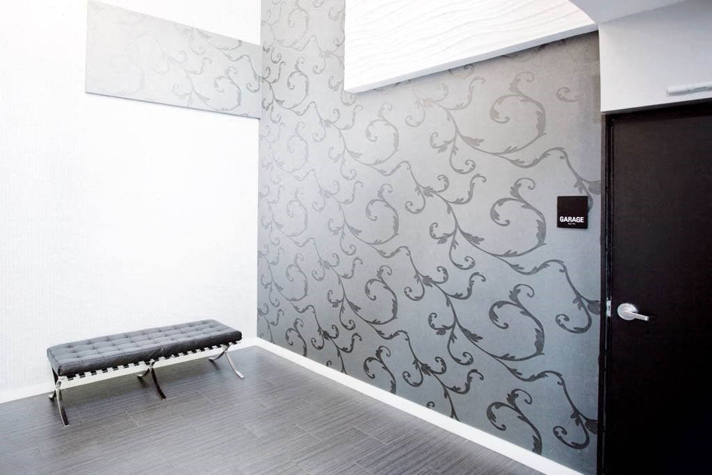 a hallway with a bench and a wall with a design on it