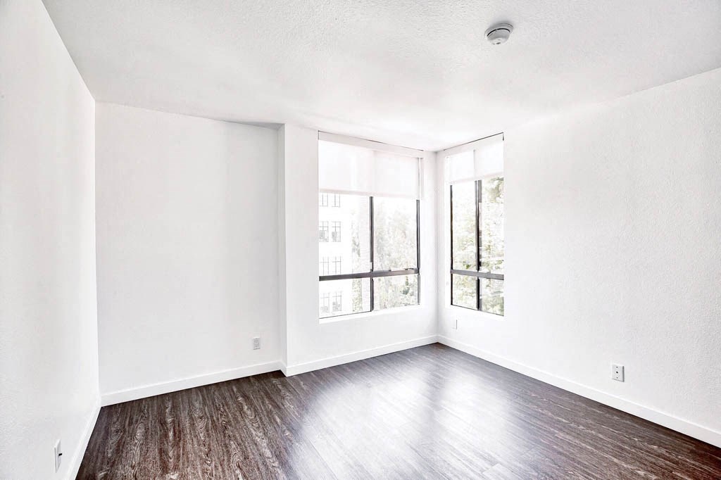 an empty living room with white walls and wood floors