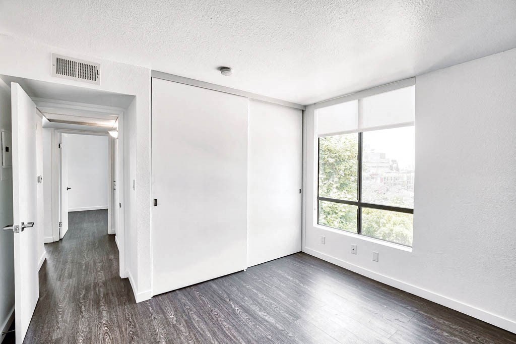 an empty living room with white walls and a window