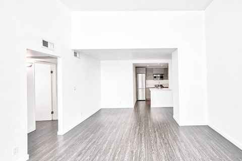 an empty living room with white walls and wood floors