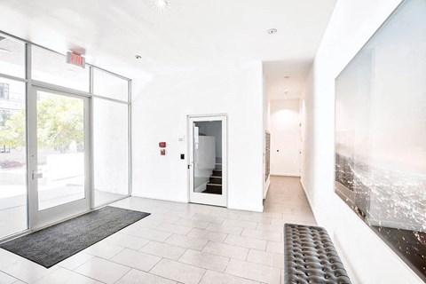 the entrance of a building with white walls and glass doors