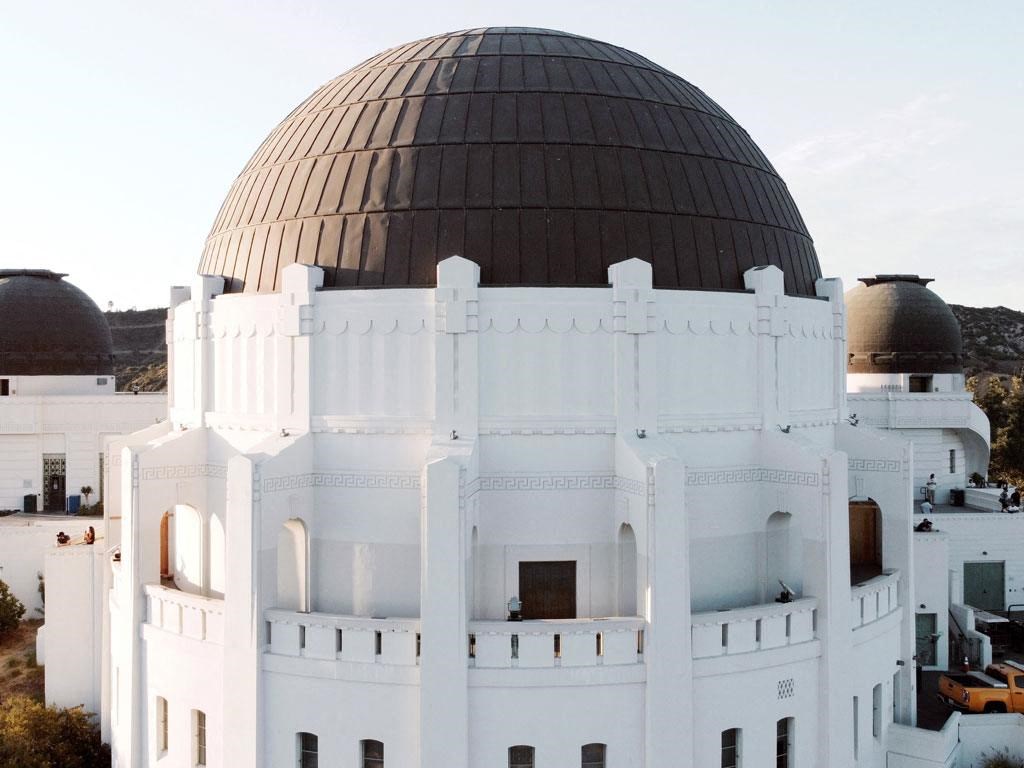 the top of a white building with a brown observatory behind it