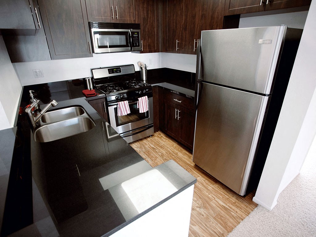 a kitchen with stainless steel appliances and black counter tops