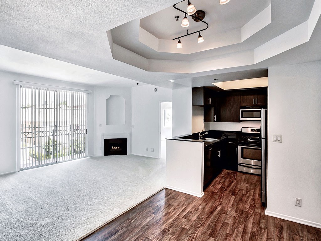 an empty living room and kitchen with a large window