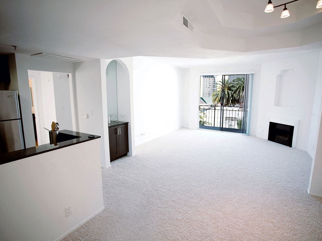 an empty living room with a fireplace and a window