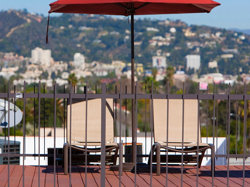 a deck with chairs and an umbrella overlooking a city