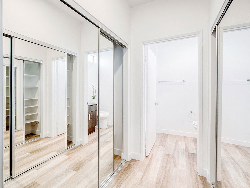 a bedroom with a mirror and a closet