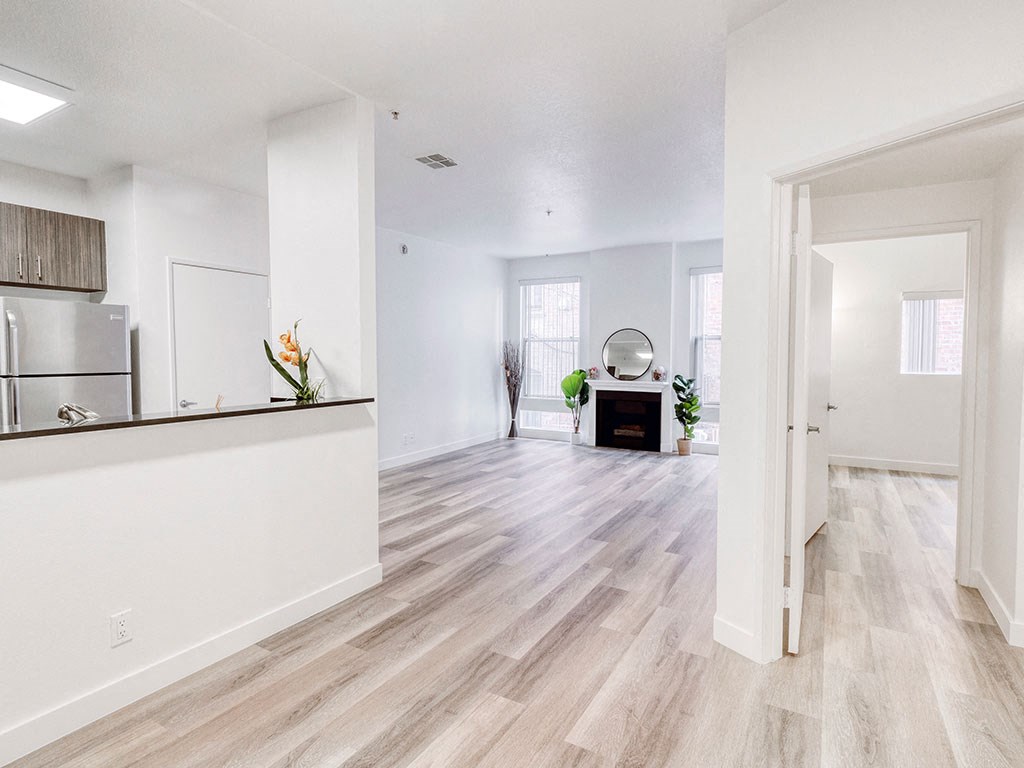 an open living room and kitchen with a hard wood floor