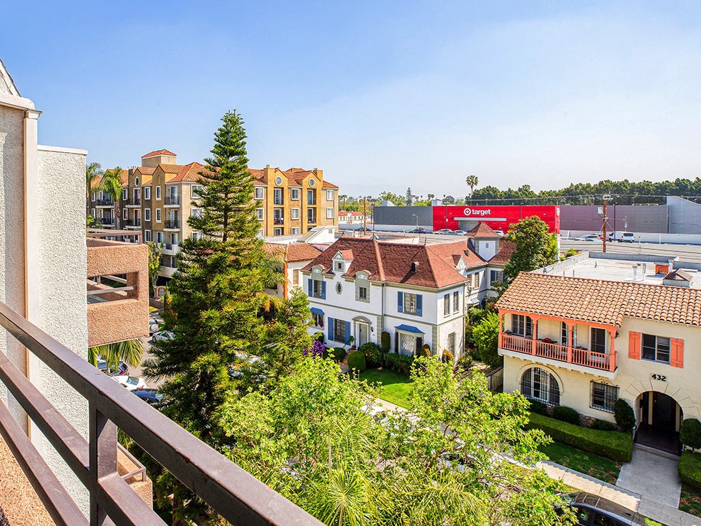a view of the city from a balcony with trees and buildings
