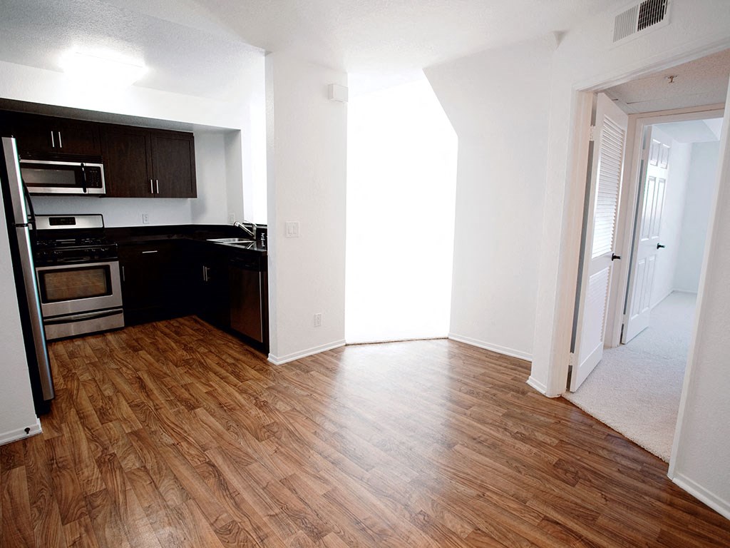 an empty kitchen and living room with wood floors