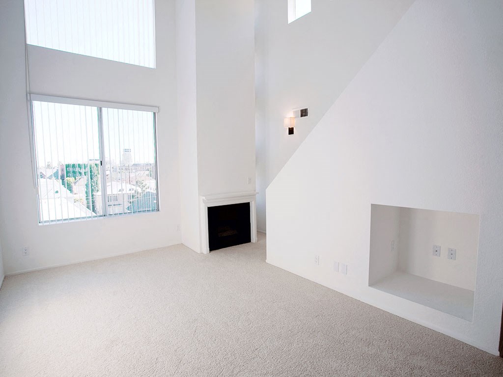 a white room with a large window and a fireplace