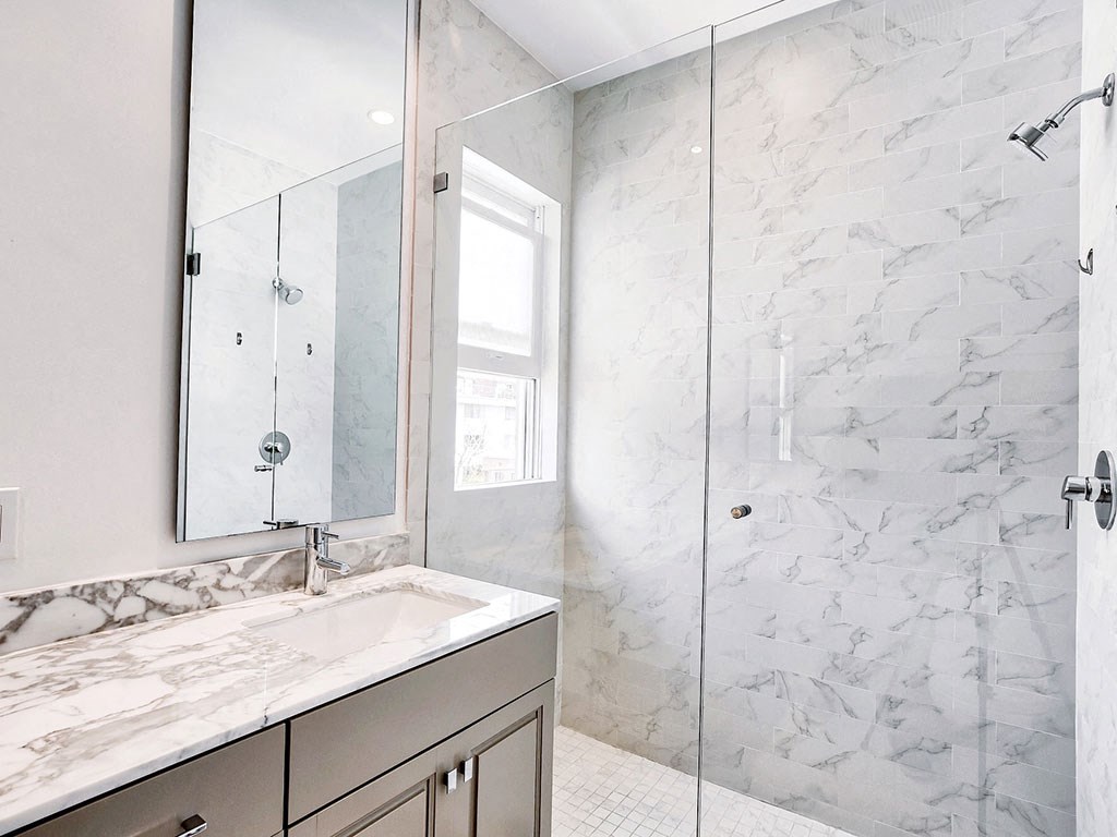 a marble bathroom with a sink and a shower