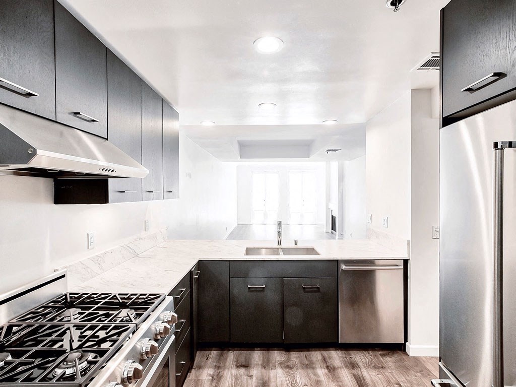an all white kitchen with stainless steel appliances and black cabinets