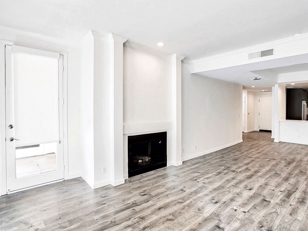 an empty living room with a fireplace and white walls