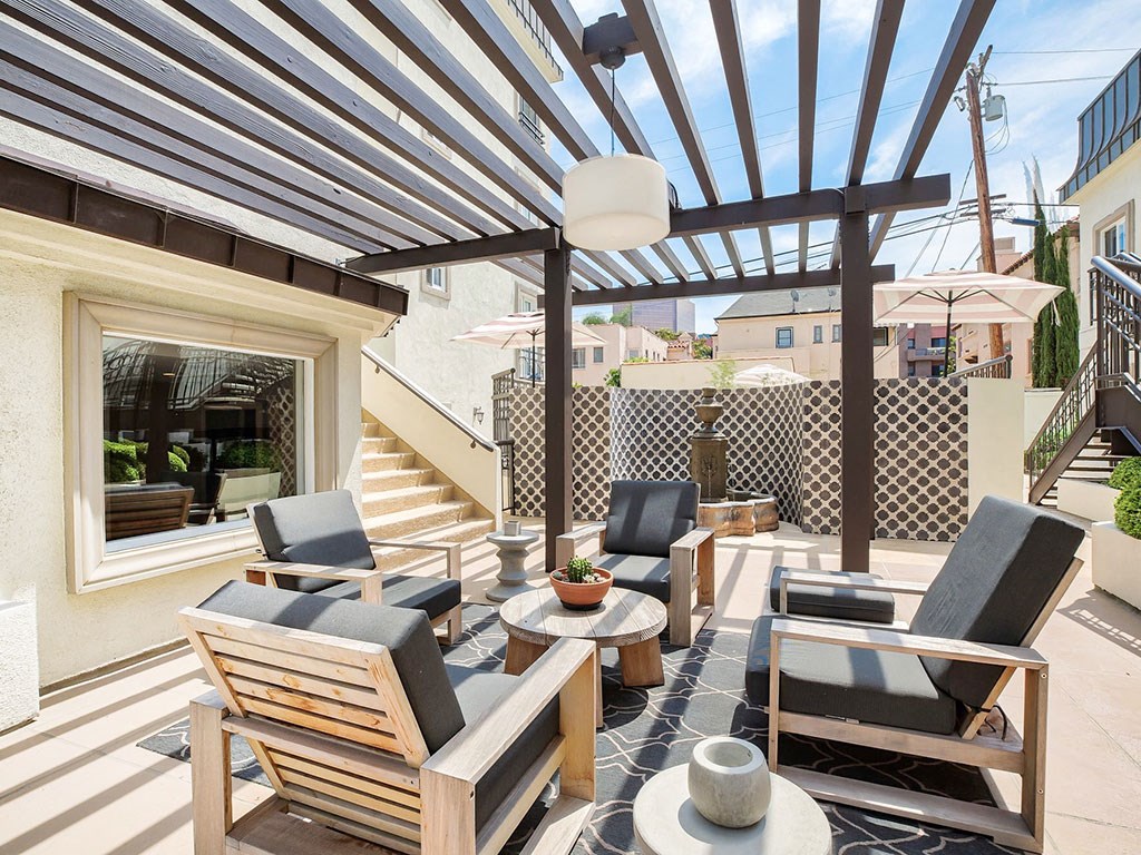 a patio with chairs and tables under awning