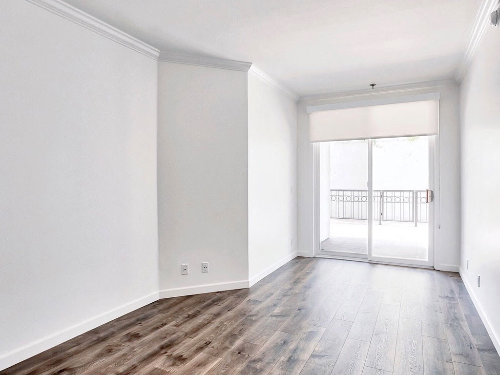 an empty living room with white walls and wood floors