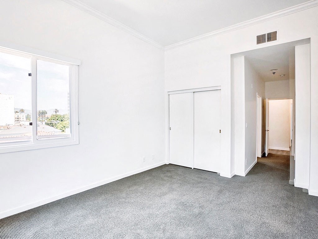 an empty room with white walls and a window