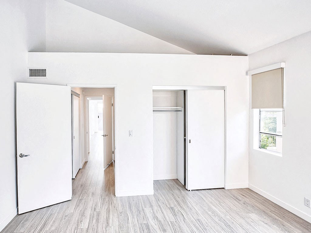 an empty room with white walls and sliding doors