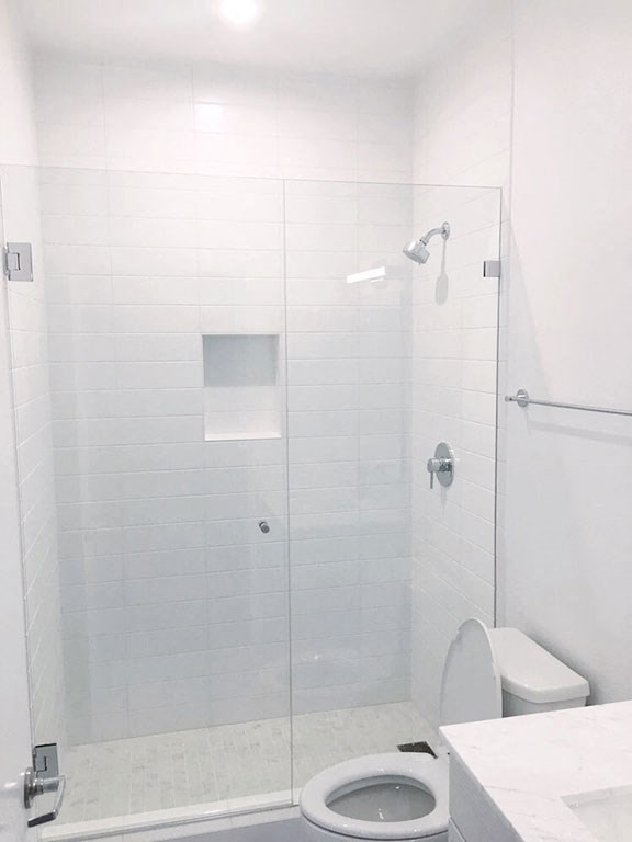 a white bathroom with a shower and a toilet