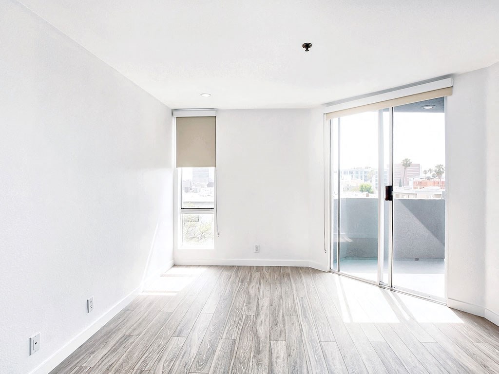 an empty living room with white walls and a sliding glass door