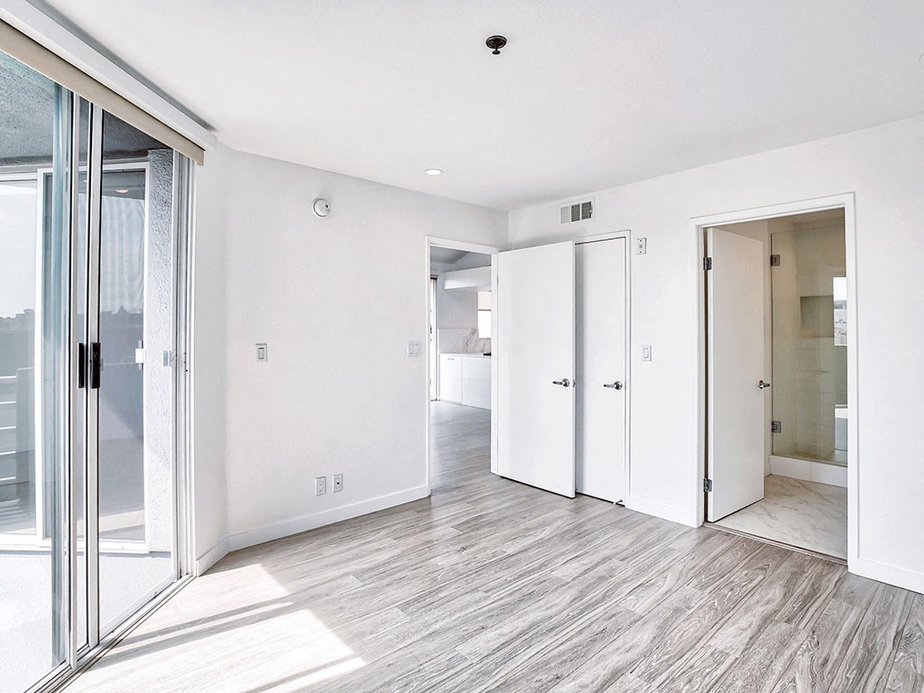 an empty living room with sliding glass doors to a bathroom