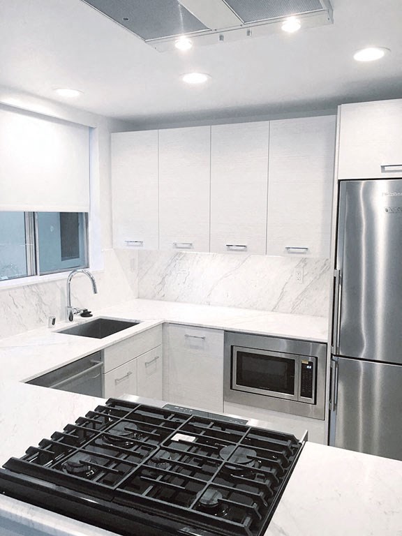 a white kitchen with a stove and a refrigerator