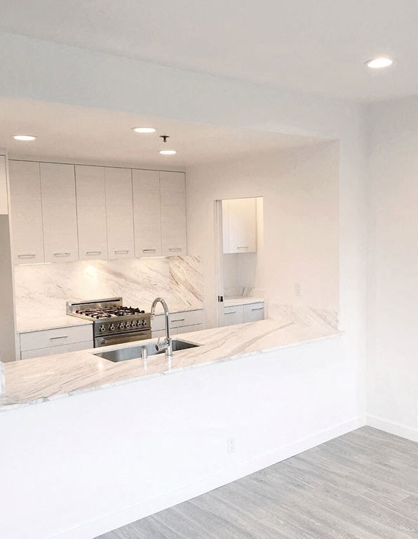 a white kitchen with white cabinets and a sink