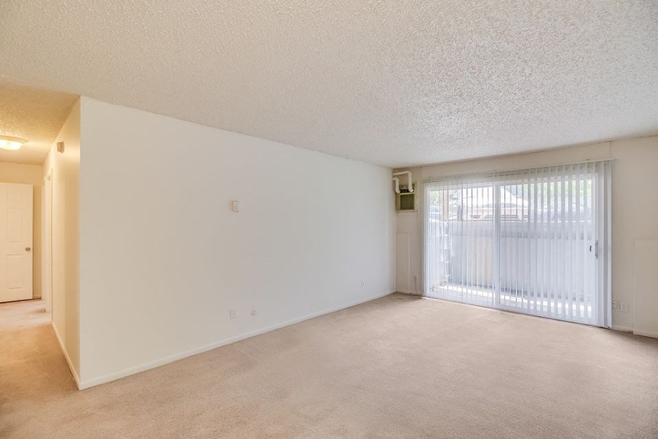the spacious living room and sliding glass door to the patio