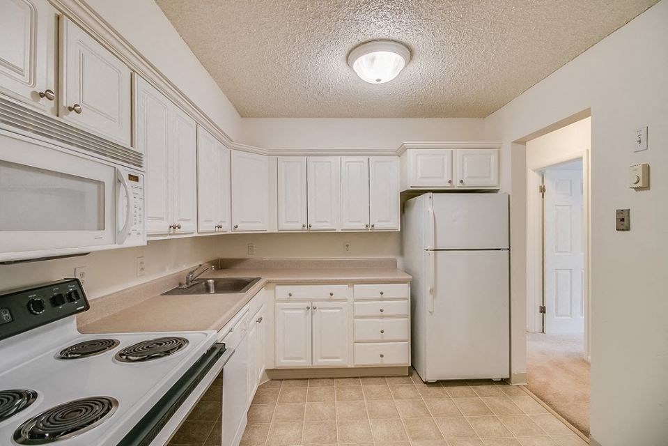 a white kitchen with white appliances and white cabinets