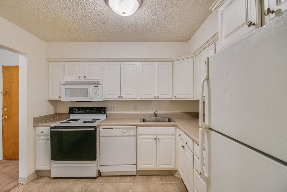 a white kitchen with white appliances and white cabinets