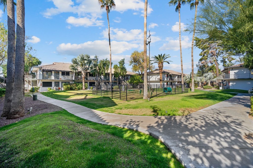 a walkway through the park at the whispering winds apartments in pearland, tx