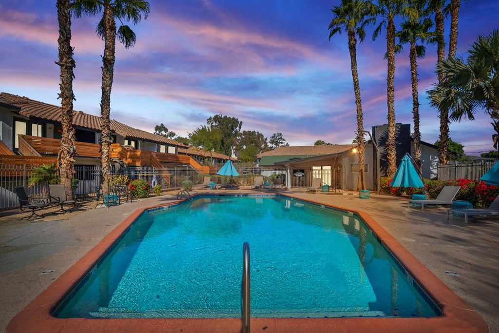 a swimming pool with palm trees in the background