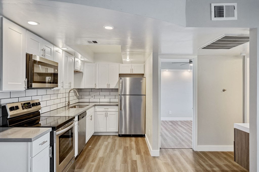 a kitchen with white cabinets and stainless steel appliances