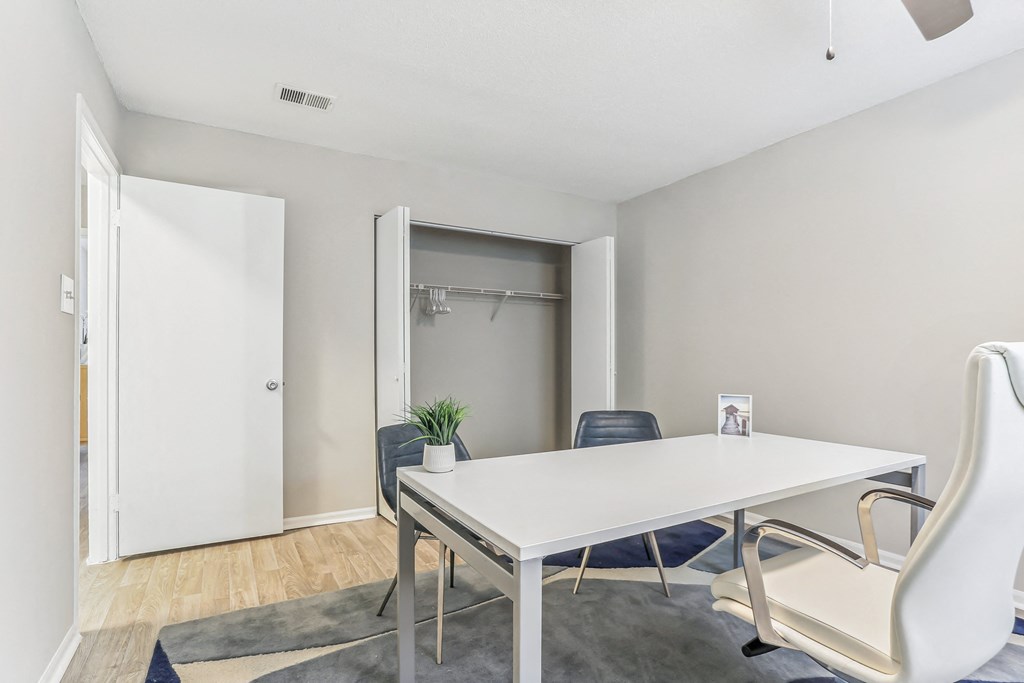 a meeting room with a white table and chairs and a closet in the background