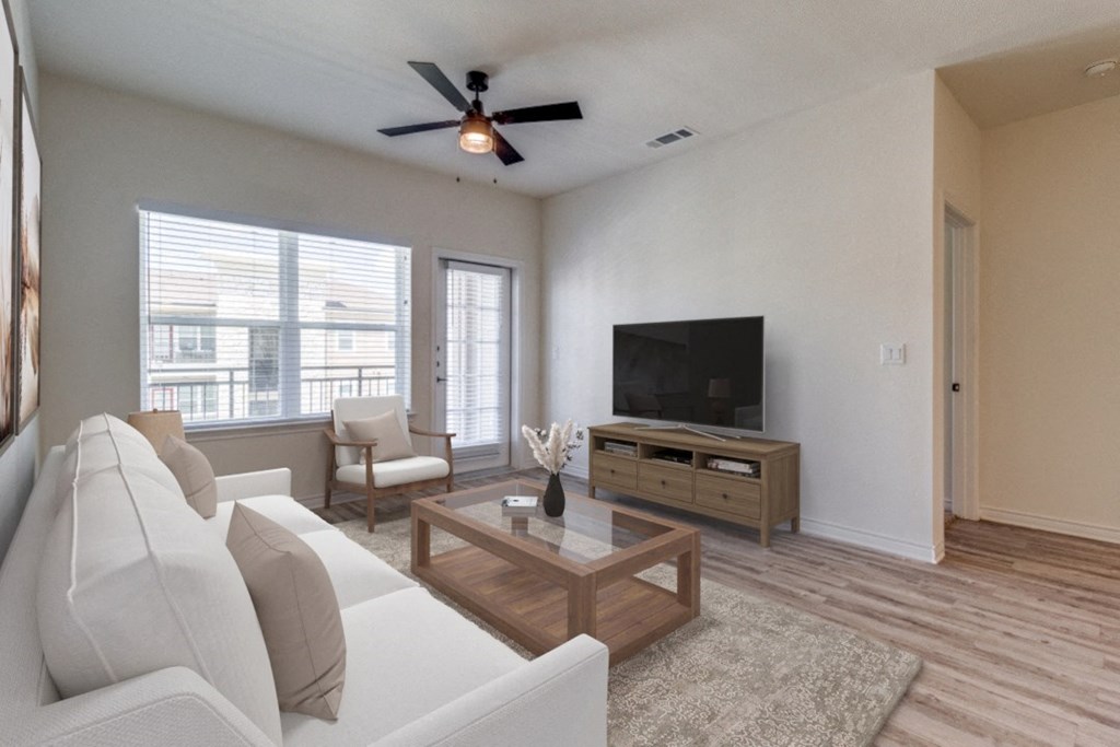 the living room of an apartment with a couch and a tv