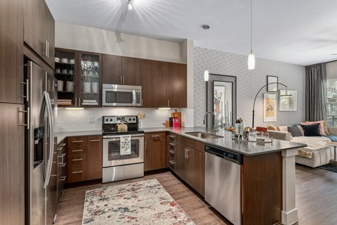 A modern kitchen with dark wood cabinets and stainless steel appliances.