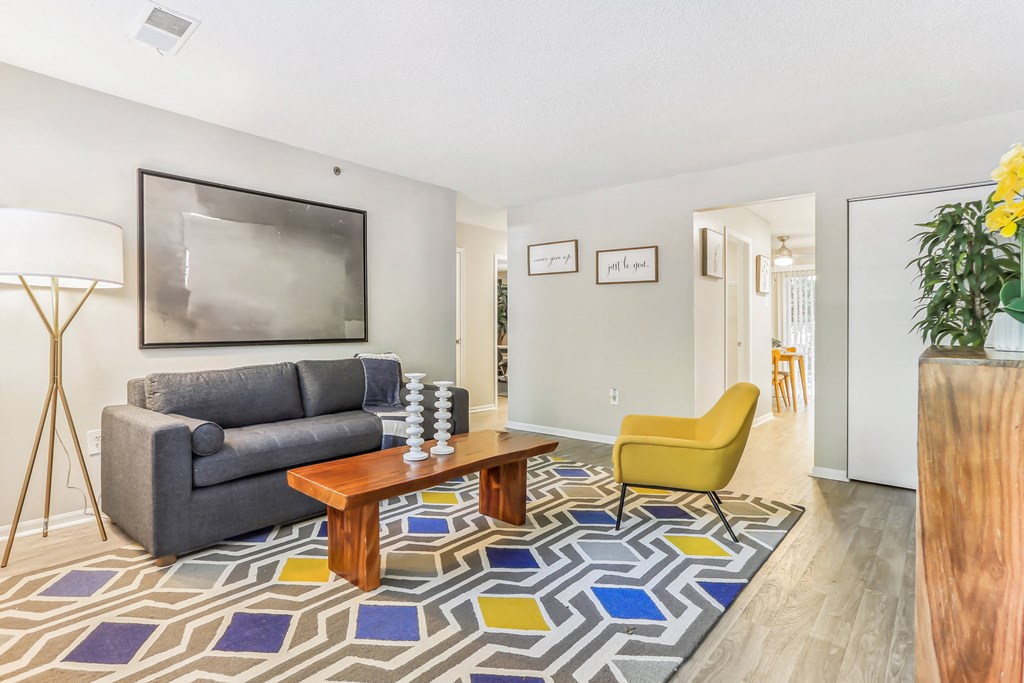 a living room with a couch coffee table and yellow chair